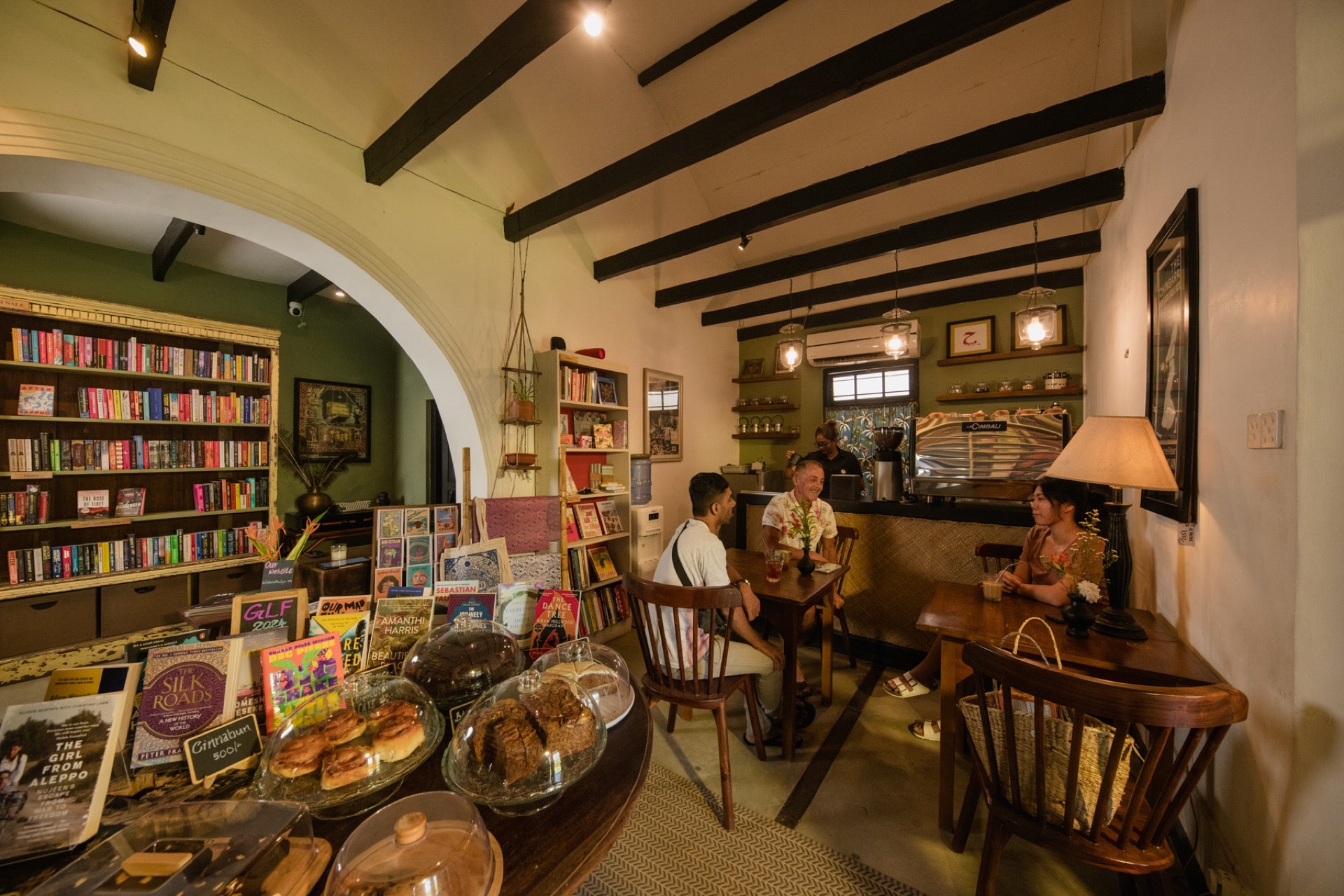 Interior of the café at Wild & The Sage, a bookshop & kitchen in Galle – featuring books, cake and coffee