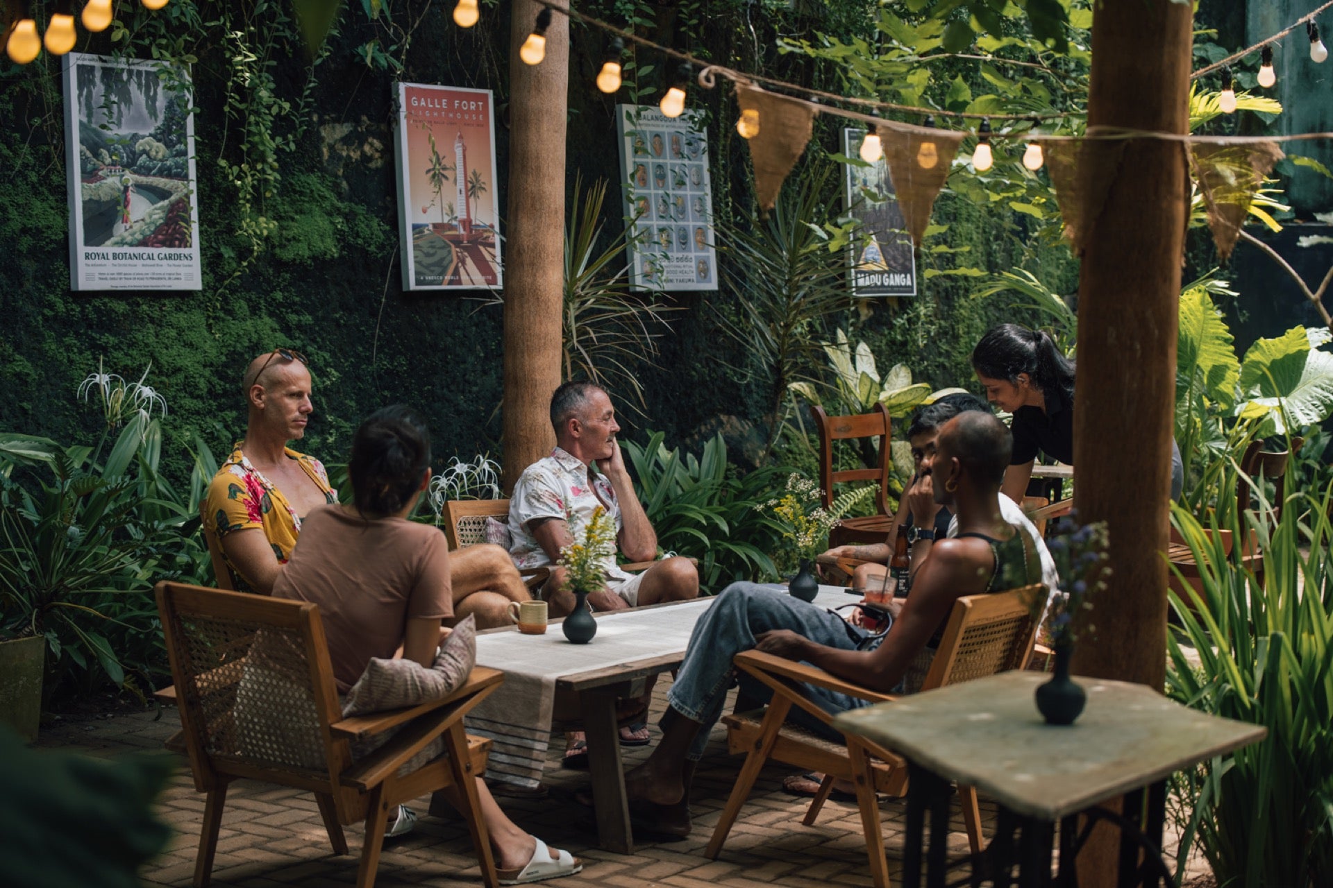 Diners sitting in the garden courtyard at Wild & the Sage – a café, restaurant and bookshop in Galle, Sri Lanka