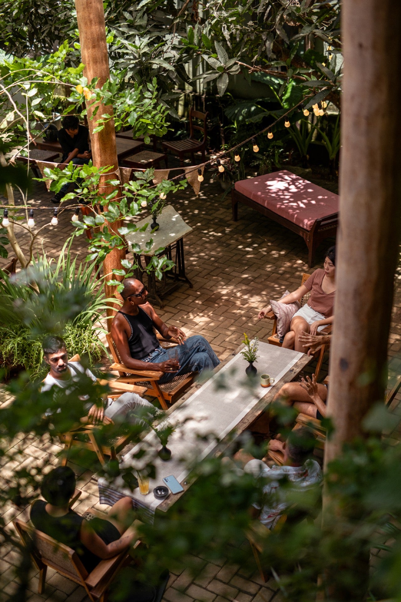 A view of diners in the garden courtyard at Wild & the Sage, a bookshop, café and restaurant in Galle