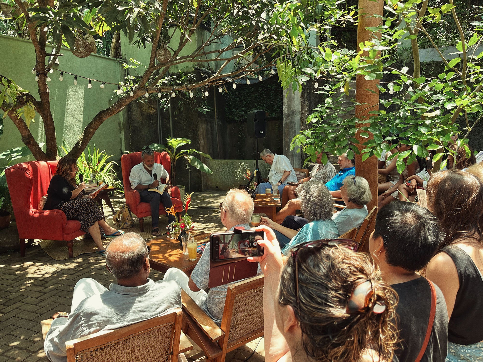 Booker Prize-winning author Shehan Karunatilaka reading to guests in the garden courtyard at Wild & the Sage bookshop in Galle